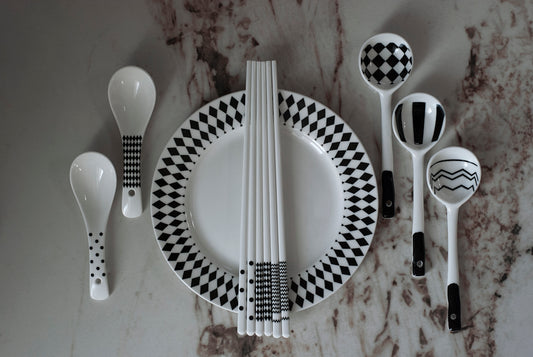 A table with a plate, spoons, and utensils on it