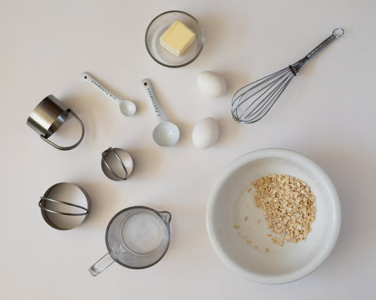 Baking ingredients and tools arranged on a white surface